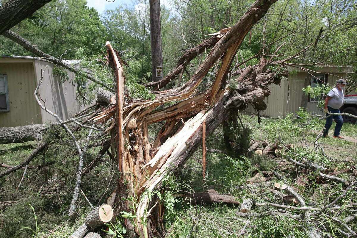 Workers remove shattered tree debris from a mobile home park south of town after storm damage in Kerrville on May 28, 2020.