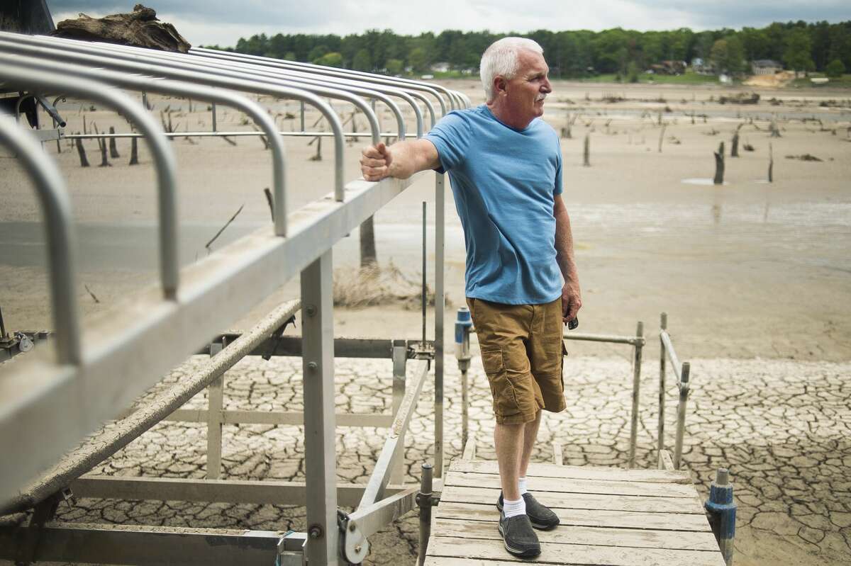 Bill Huss looks out from his dock across what was once a full Sanford Lake and is now a barren, muddy expanse, Thursday, May 28, 2020 in Sanford. (Katy Kildee/kkildee@mdn.net)