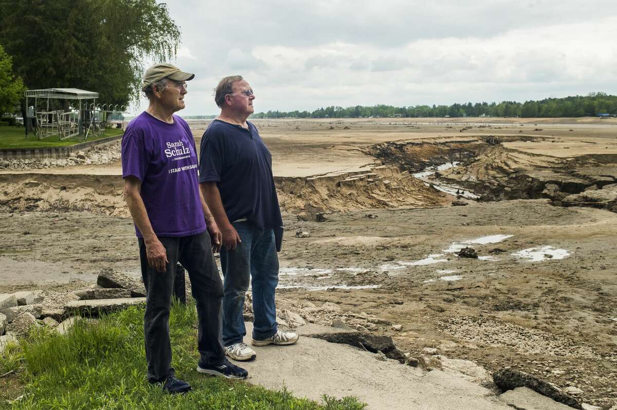 FILE — John McPeak, left, and Eric McPeak, right, look out across the muddy surface of Wixom Lake from their family's lakefront property Thursday, May 28, 2020 in Hope. (Katy Kildee/kkildee@mdn.net)