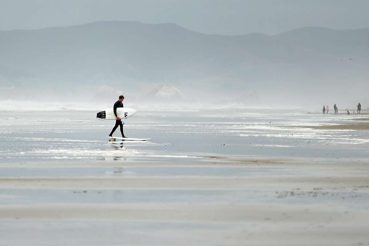 After a couple hours of surfing, Brian Duffy of Mill Valley walks out of the water at Ocean Beach in San Francisco, Calif., on Wednesday, May 13, 2020.