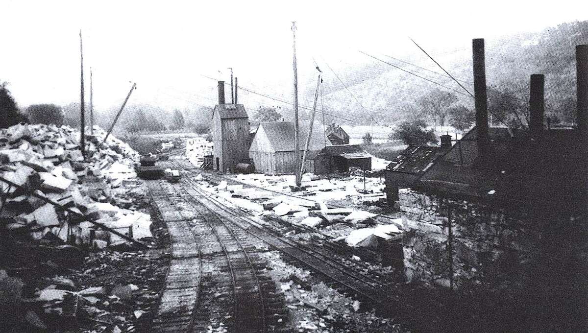 Stoneworkers in 1905 walked across the Shepaug River on a suspension bridge to reach the Rockside Quarry at Mine Hill in Roxbury. This photo by Joseph West shows cut granite, ready to be hauled down the mountainside on narrow-gauge rails, where it was shipped to Bridgeport, New York City or other locations. Before the Shepaug Valley Railroad opened in 1871, ox carts provided the means of transportation for the rocks.