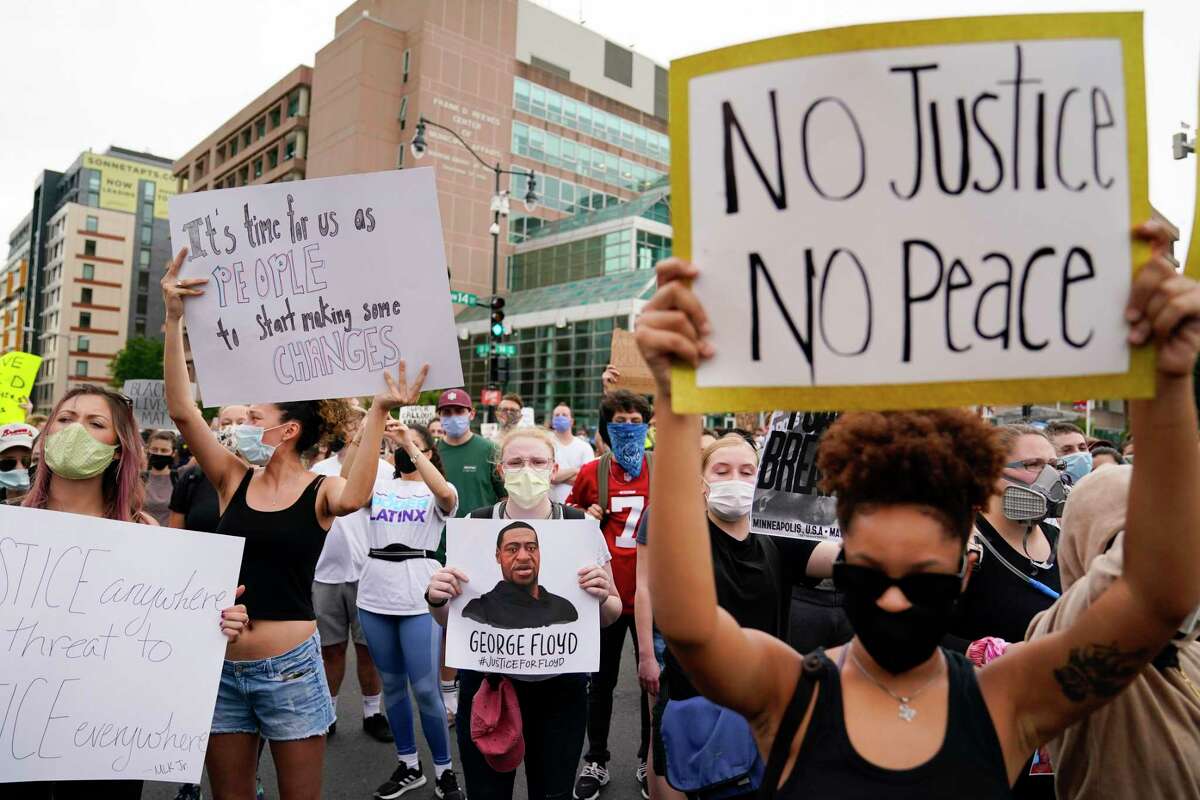 Demonstrators gather to protest the death of George Floyd, a black man who died in police custody in Minneapolis, at the corner of 14th and U streets in Washington, Friday, May 29, 2020.