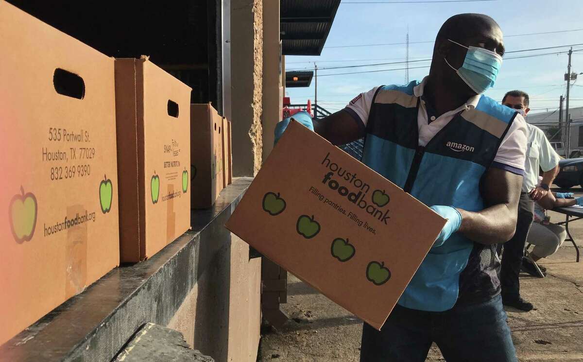 Sakariyah Adegoke loads weekly food boxes into his minivan for delivery at the Houston Food Bank warehouse on Market Street Road in Houston, Texas on Friday, May 29, 2020. Adegoke drives for Amazon Flex, the company's two-hour home delivery service, which under a partnership with the food bank is paying for up to 750 deliveries per day.