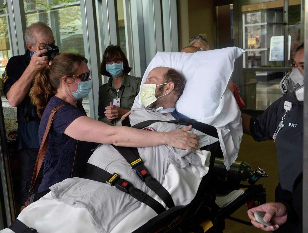 John Reed, deputy fire chief from New Rochelle, N.Y., gets a hug from his wife Suzanne after being discharged from Danbury Hospital. Reed was in the hospital 56 days battling the coronavirus. May 29, 2020, in Danbury, Conn.