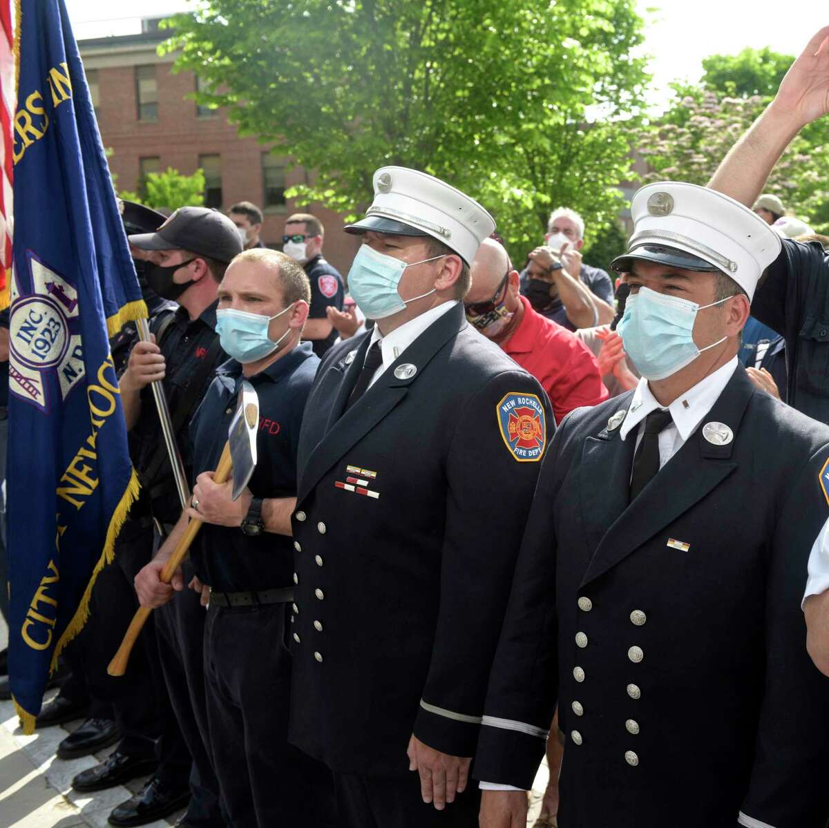 Members of the New Rochelle Fire Department watch as John Reed, deputy fire chief from New Rochelle, N.Y., leaves Danbury Hospital, after 56 days battling the coronavirus. May 29, 2020, in Danbury, Conn.