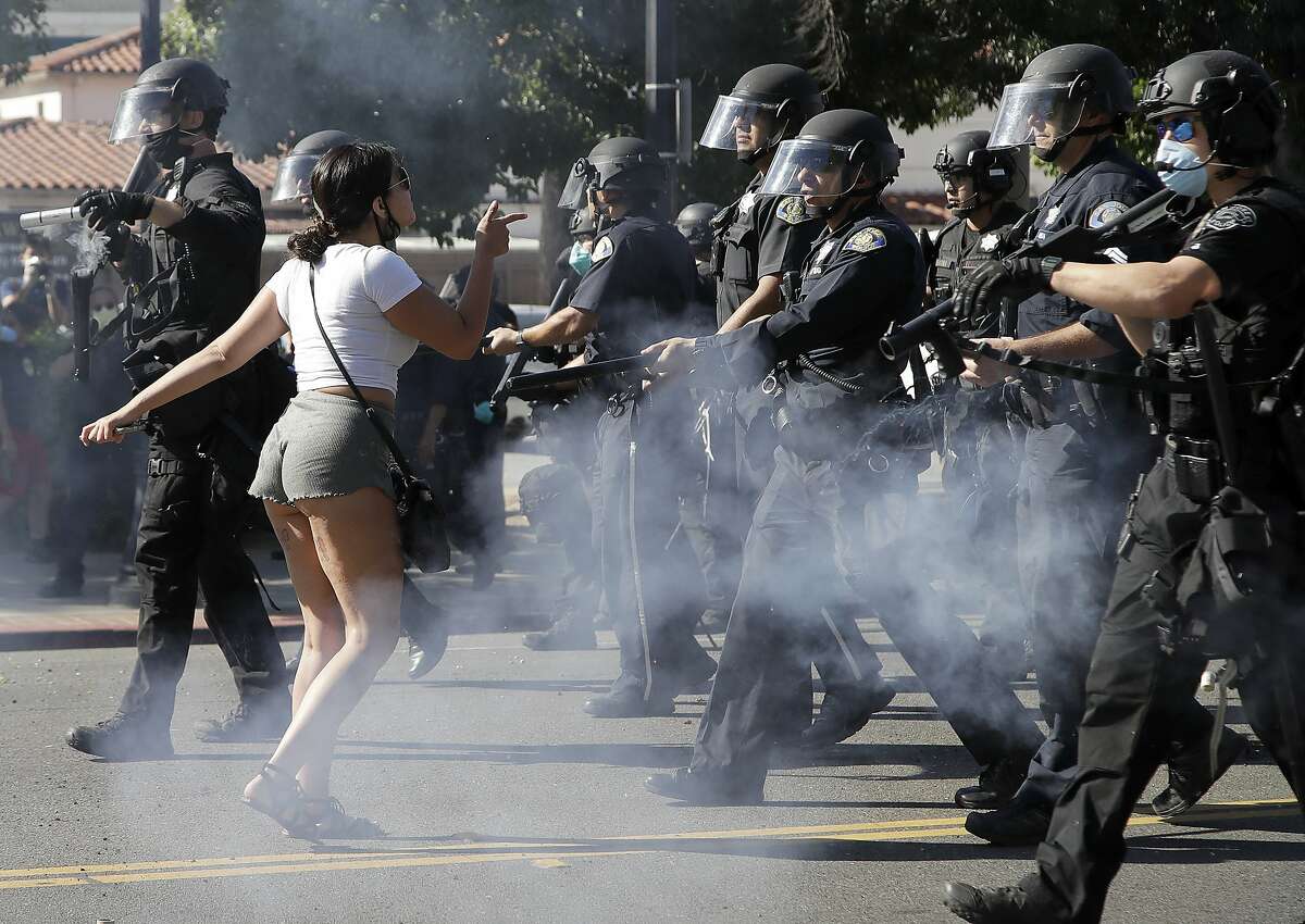 A protester confronts San Jose police as they advance on Friday, May 29, 2020, in San Jose, Calif., as people demonstrate nationwide in response to George Floyd dying while in police custody on Memorial Day, in Minneapolis. (AP Photo/Ben Margot)