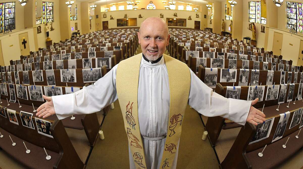 FILE - In this May 22, 2020, file photo, the Rev. Nicolas Sanchez Toledano poses among pews adorned with portraits of his parishioners at St. Patrick's Catholic Church during the coronavirus outbreak in the North Hollywood section of Los Angeles. California says churches can resume in-person services but the congregations will be limited to less than 100 and worshippers should wear masks, avoid sharing prayer books and skip the collection plate. The state Department of Public Health released a framework Monday, May 25, for county health officials to permit houses of worship to reopen. (AP Photo/Mark J. Terrill, File)