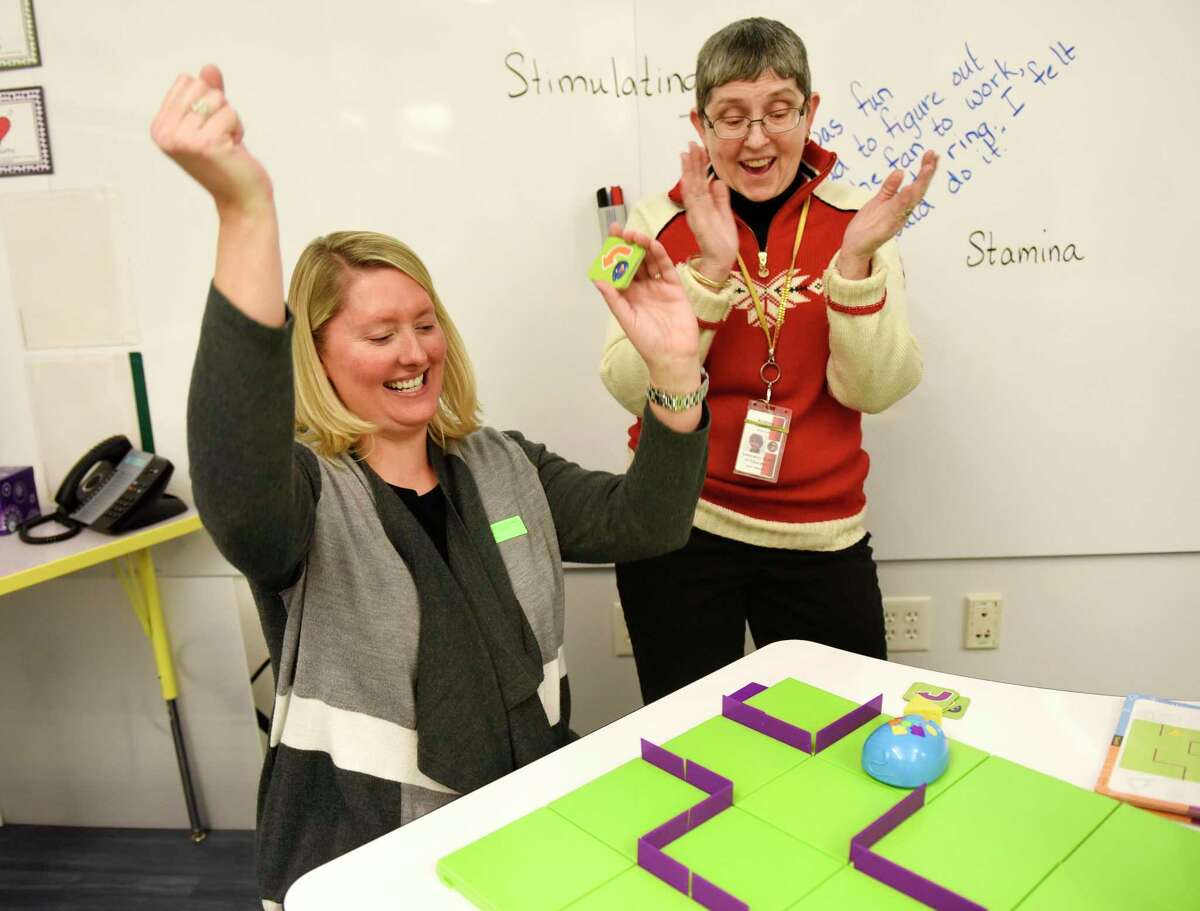 PTA co-president Erica Westfall, left, and Media Assistant Andrea Casson Vaz celebrate after successfully programming a mechanical mouse to reach its cheese during the launch of the new Design Lab at Glenville School in the Glenville section of Greenwich, Conn. Tuesday, Jan. 22, 2019. The Design Lab is an extension of the school's Media Center and features a variety of STEM activities for students to explore.
