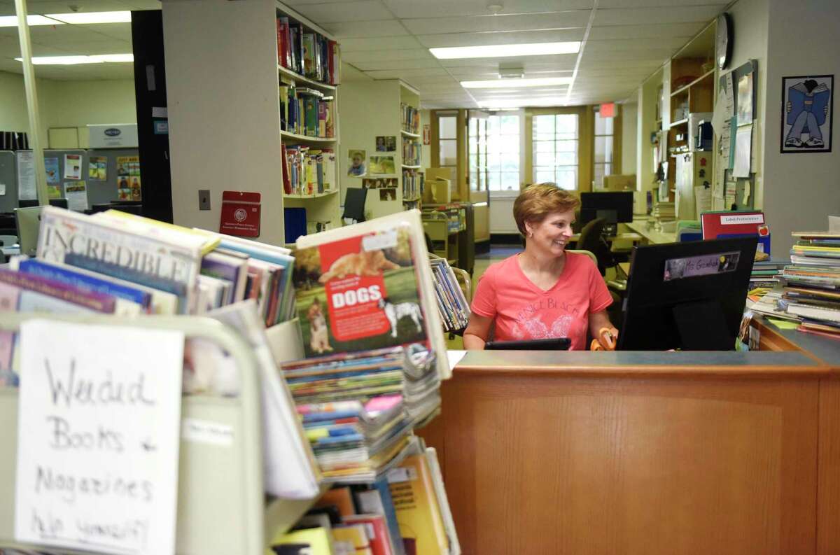 Media Assistant Ellen Gramlich "weeds" through books in the media center at Riverside School in the Riverside section of Greenwich, Conn. Monday, Aug. 24, 2015. The weeded books, usually those that are unpopular among students or damaged, are first given to teachers at the school with the rest being donated to the town surplus sale. The first day of school for students is Sept. 2 and the first official day for teachers is this Thursday, Aug. 27.