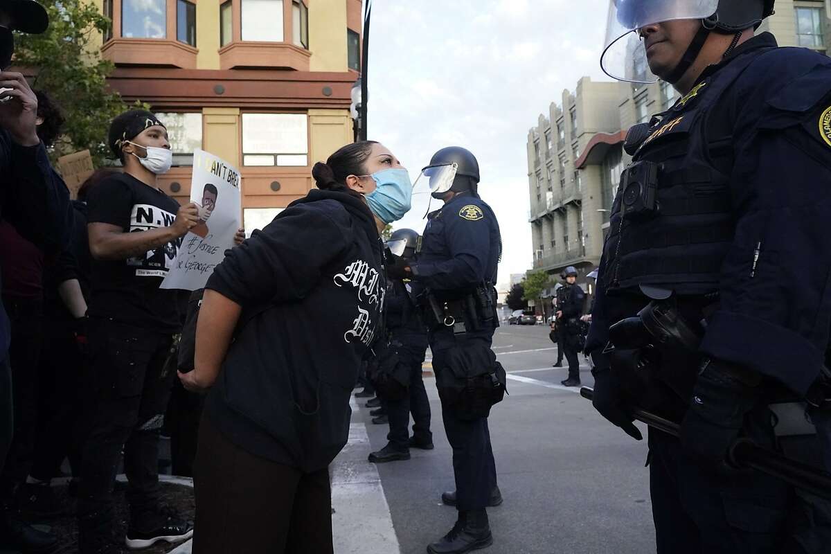 Protesters confront a police line protecting the Oakland Police Department building on 7th Street and Broadway on Friday as they protest the killing of George Floyd by police in Minneapolis.