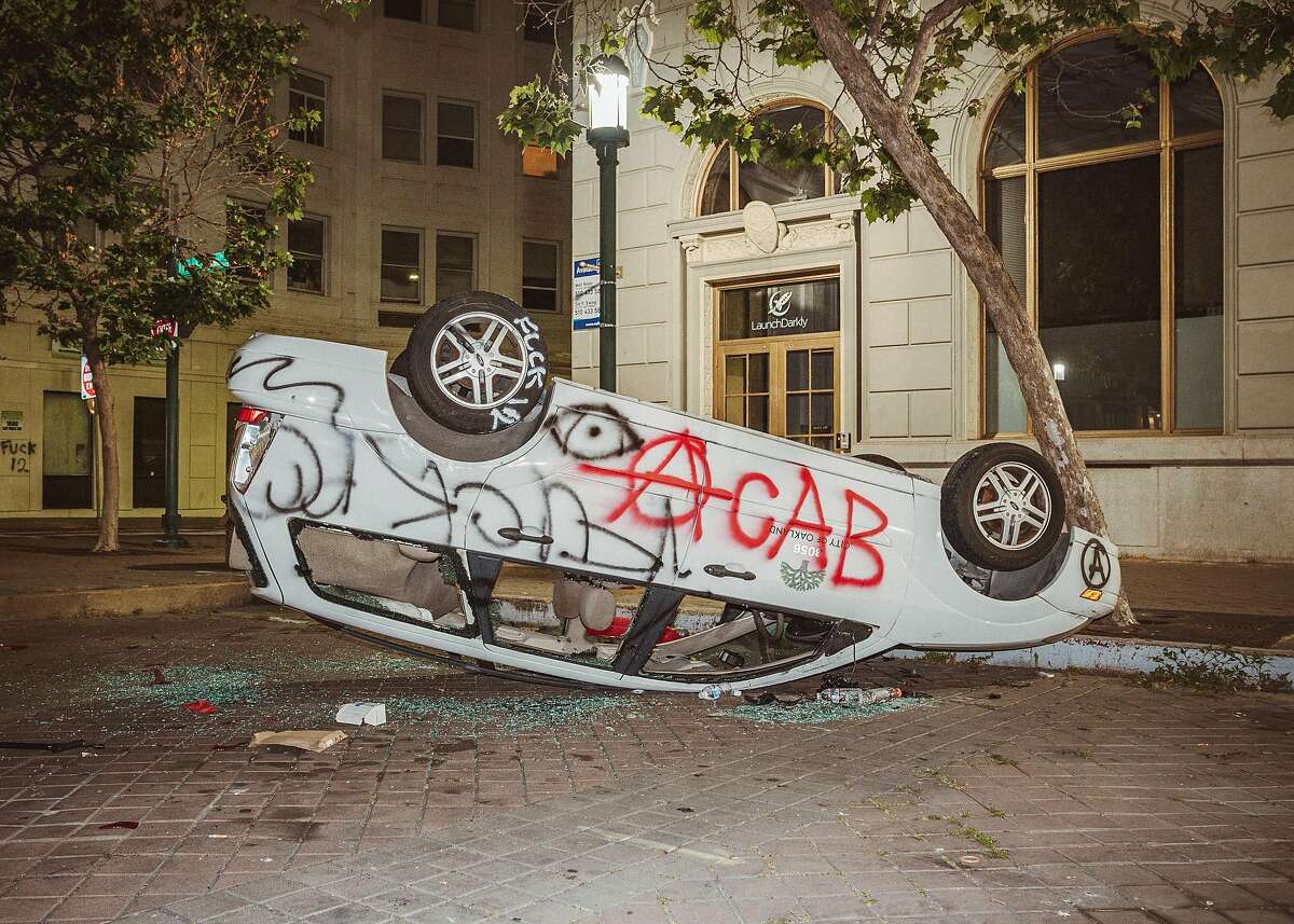 A city vehicle sits upside down in in Frank Ogawa Plaza in Oakland, Calif. on Friday, May 29, 2020.