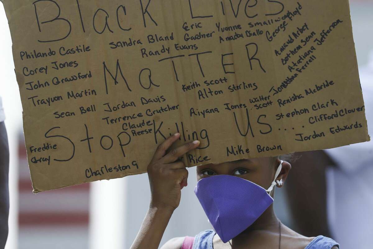 Kailia Allen, 8, holds a sign during a demonstration for Houston native George Floyd, who died in custody of the Minneapolis police earlier this week, during a rally Saturday, May 30, 2020, at Emancipation Park in Houston.
