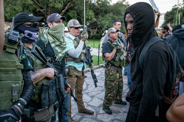 Protestors and military-style groups confronted each other in front of the Alamo.