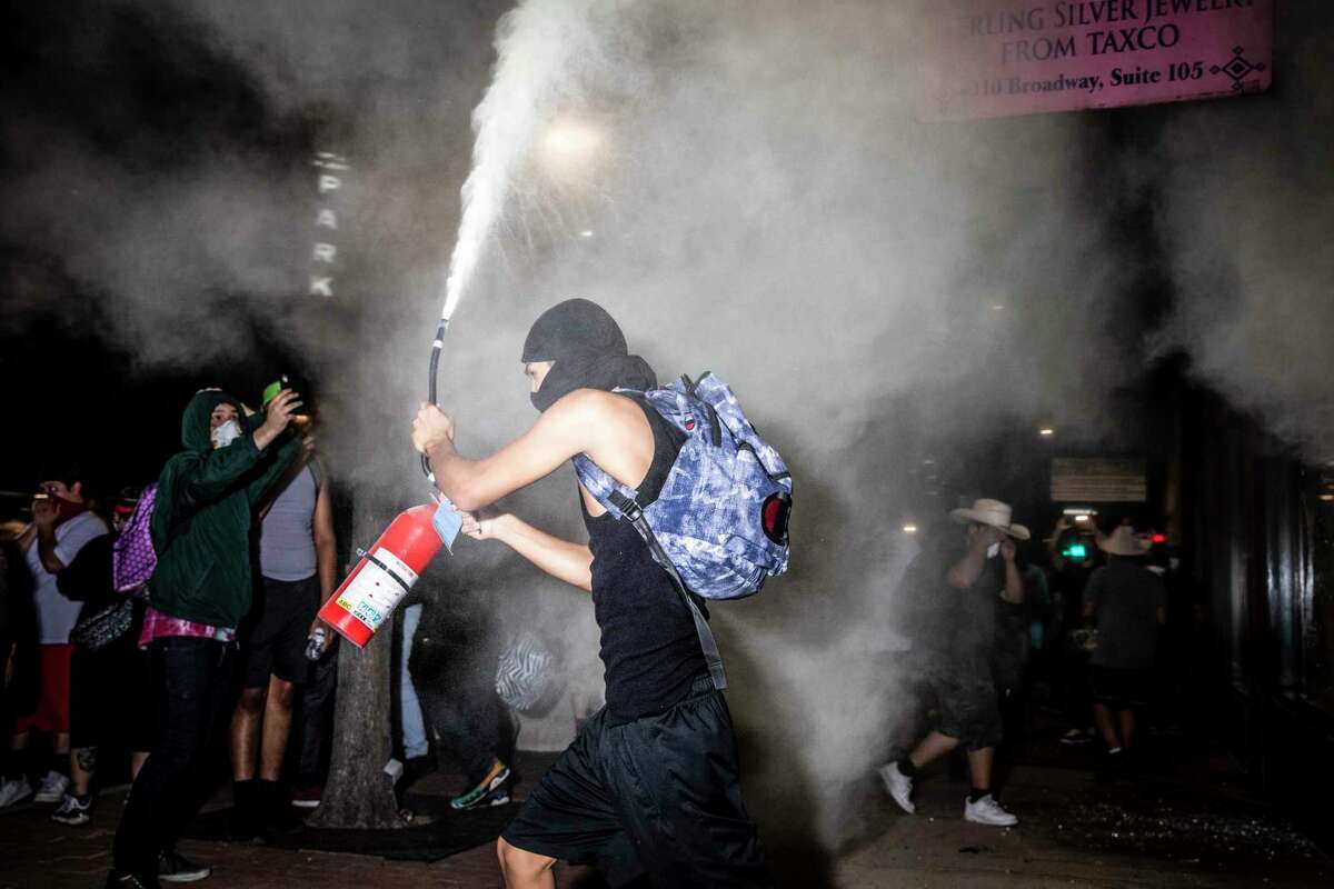A protestor lets off a fire extinguisher in downtown San Antonio, Texas, U.S. on Saturday, May 30, 2020. People took to the streets of San Antonio to protest the killing of George Floyd in Minnesota while he was in police custody. Looting took place in downtown Houston street as police fired tear gas and pepper balls at protestors as they looted stores.