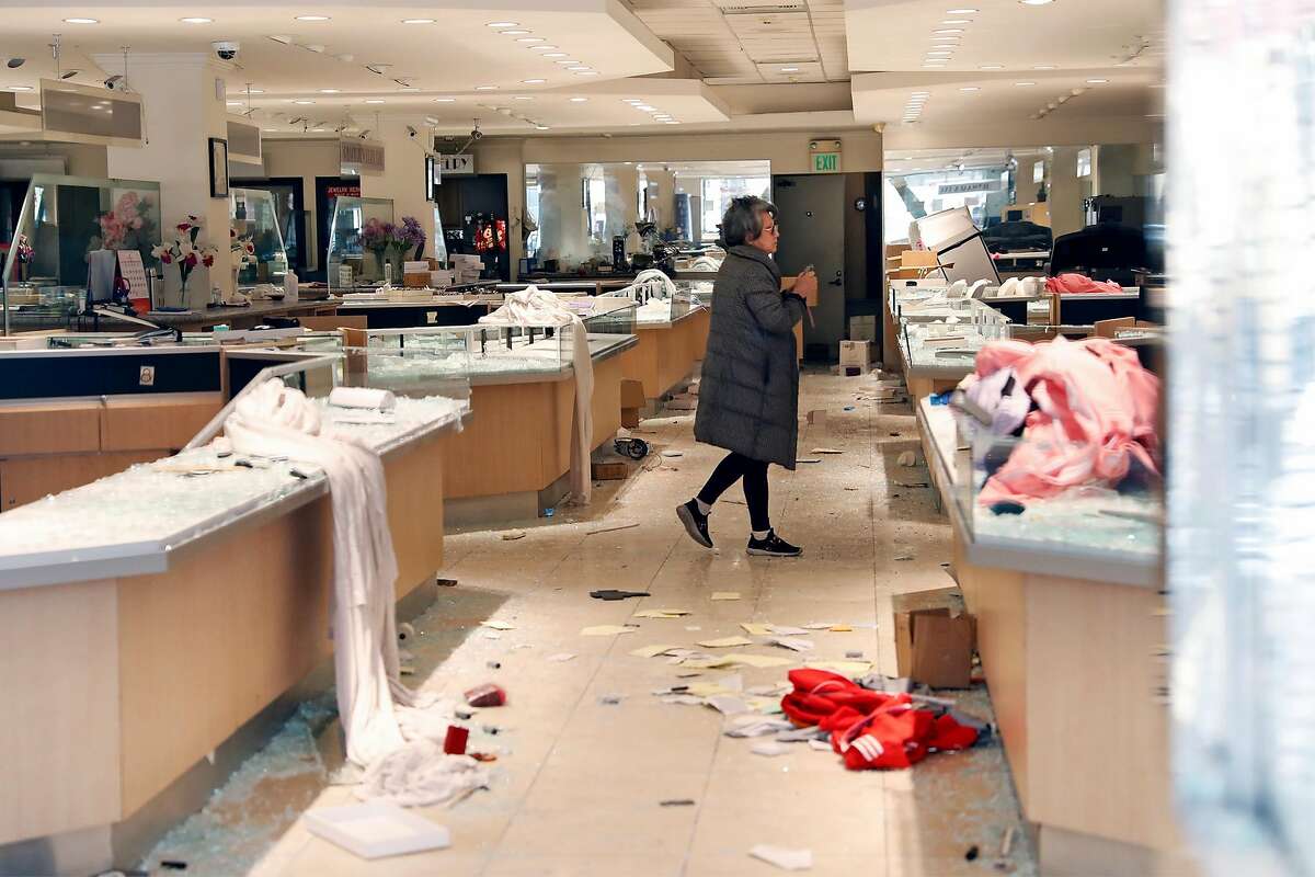 A woman walks through Grace Jewelry on O'Farrell Street in aftermath of looting in San Francisco, Calif., on Sunday, May 31, 2020.