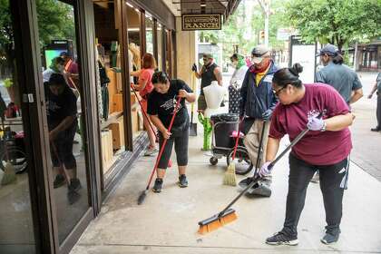 Volunteers help to clean up the damage done to the store San Antonio Ranch on Houston Street in downtown San Antonio, Texas, U.S. on Sunday, May 31, 2020. The day followed a night of protests in downtown San Antonio where business frontÕs were damaged and some businesses were looted. Saturday saw hundreds of people gather in downtown San Antonio to protest the death of George Floyd in Minnesota while he was in police custody.