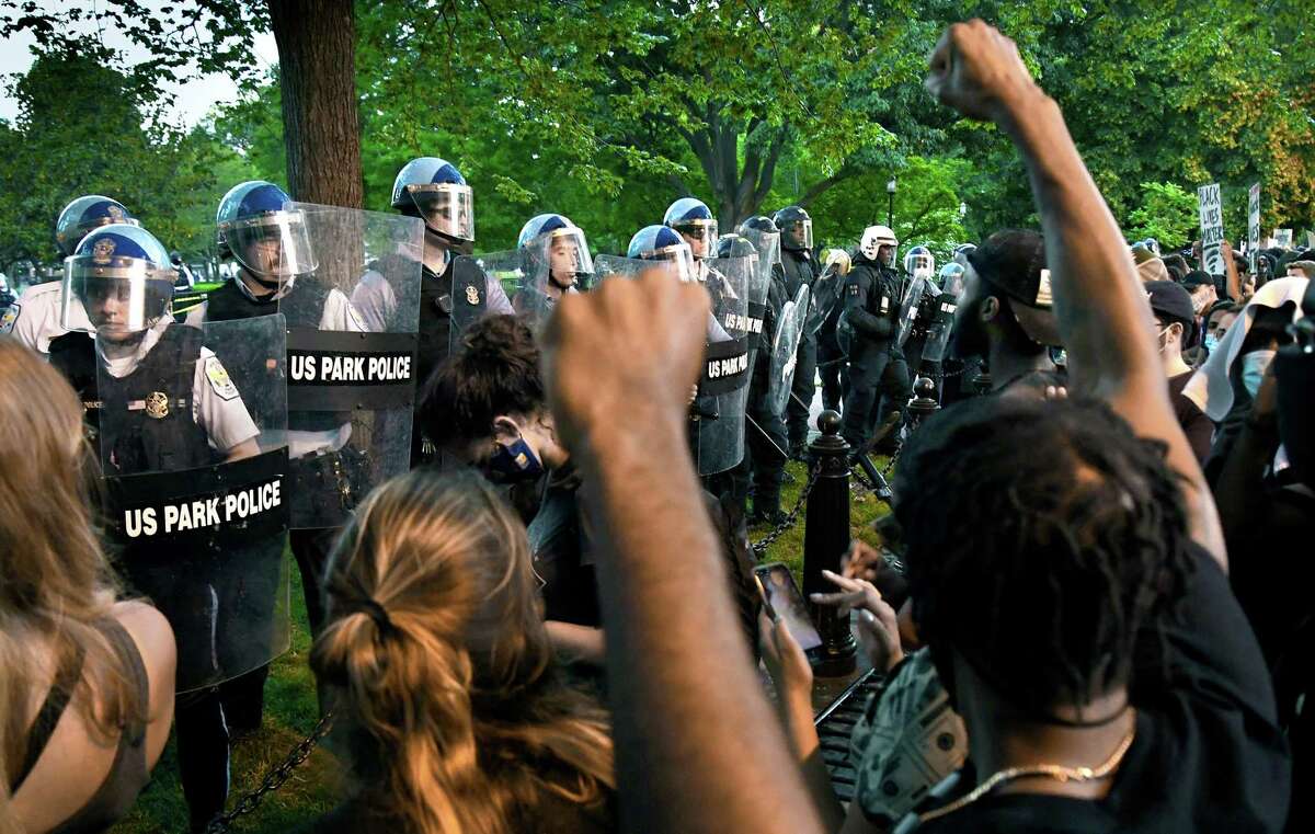 Police officers confront protesters near Lafayette Square in Washington, D.C., on Saturday. In several other cities across the country, journalists reported being physically confronted or arrested by police while they tried to cover the protests.