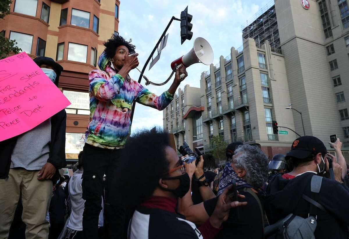 OAKLAND, CALIFORNIA - MAY 29: People participate in a protest sparked by the death of George Floyd while in police custody on May 29, 2020 in Oakland, California. Earlier today, former Minneapolis police officer Derek Chauvin was taken into custody for Floyd's death. Chauvin has been accused of kneeling on Floyd's neck as he pleaded with him about not being able to breathe. Floyd was pronounced dead a short while later. Chauvin and 3 other officers, who were involved in the arrest, were fired from the police department after a video of the arrest was circulated. (Photo by Justin Sullivan/Getty Images)