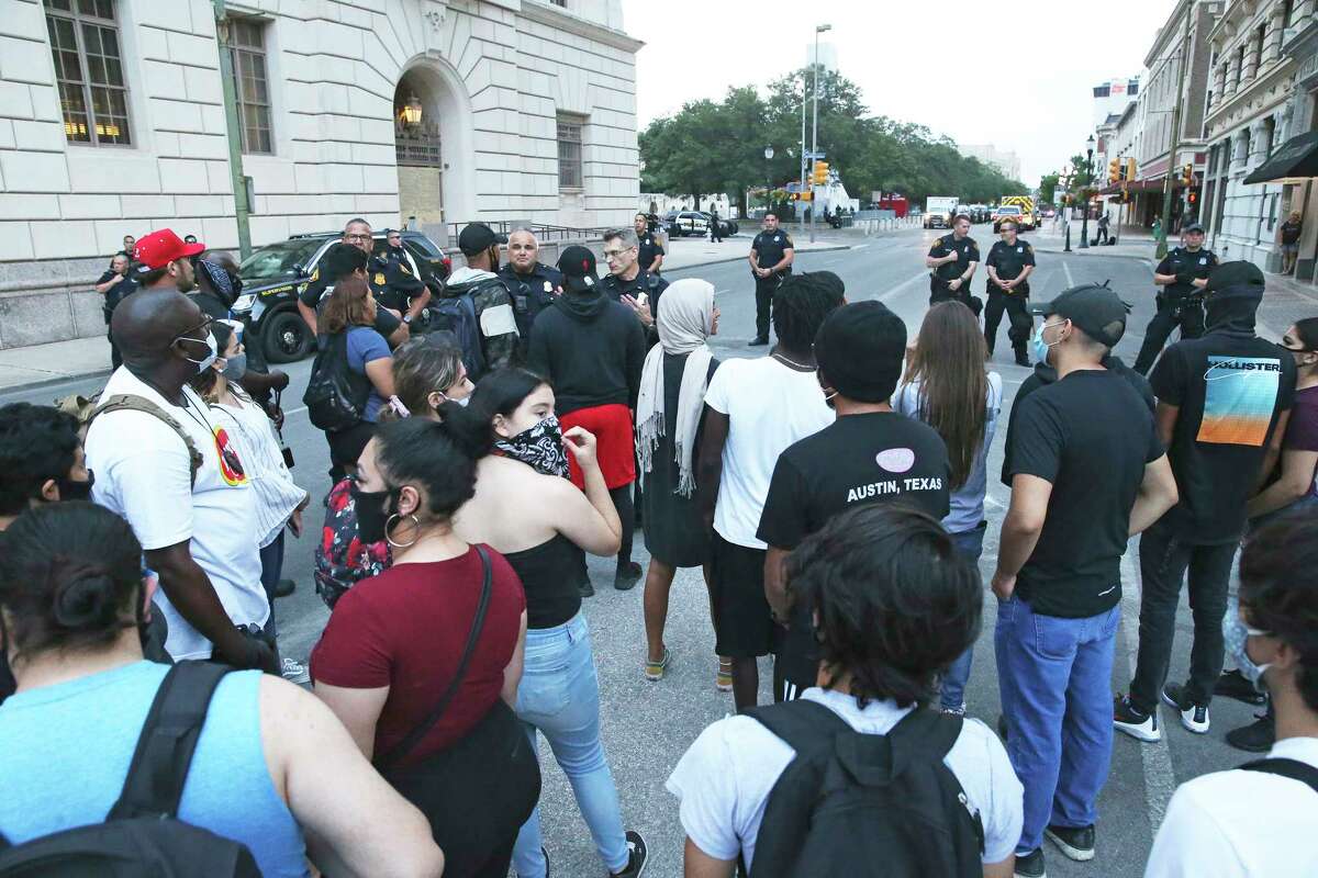 Police come forward to discuss matters with demonstrators gathered next to the federal building on Alamo Plaza on the day after the downtown riots on May 31, 2020.