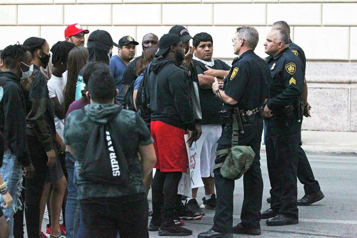 Police come forward to discuss matters with demonstrators gathered next to the federal building on Alamo Plaza on the day after the downtown riots on May 31, 2020.