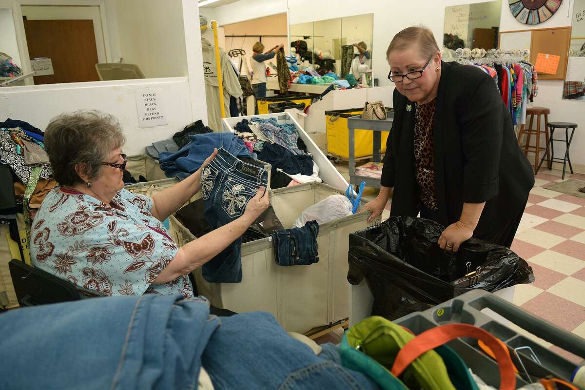 Cypress Assistance Ministries Executive Director Martha Burnes, right, chats with Sandy Kahler as Kahler sorts clothes items in the cellar of the Angels' Attic resale shop on Oct. 22, 2015. (Photo by Jerry Baker/Freelance)4