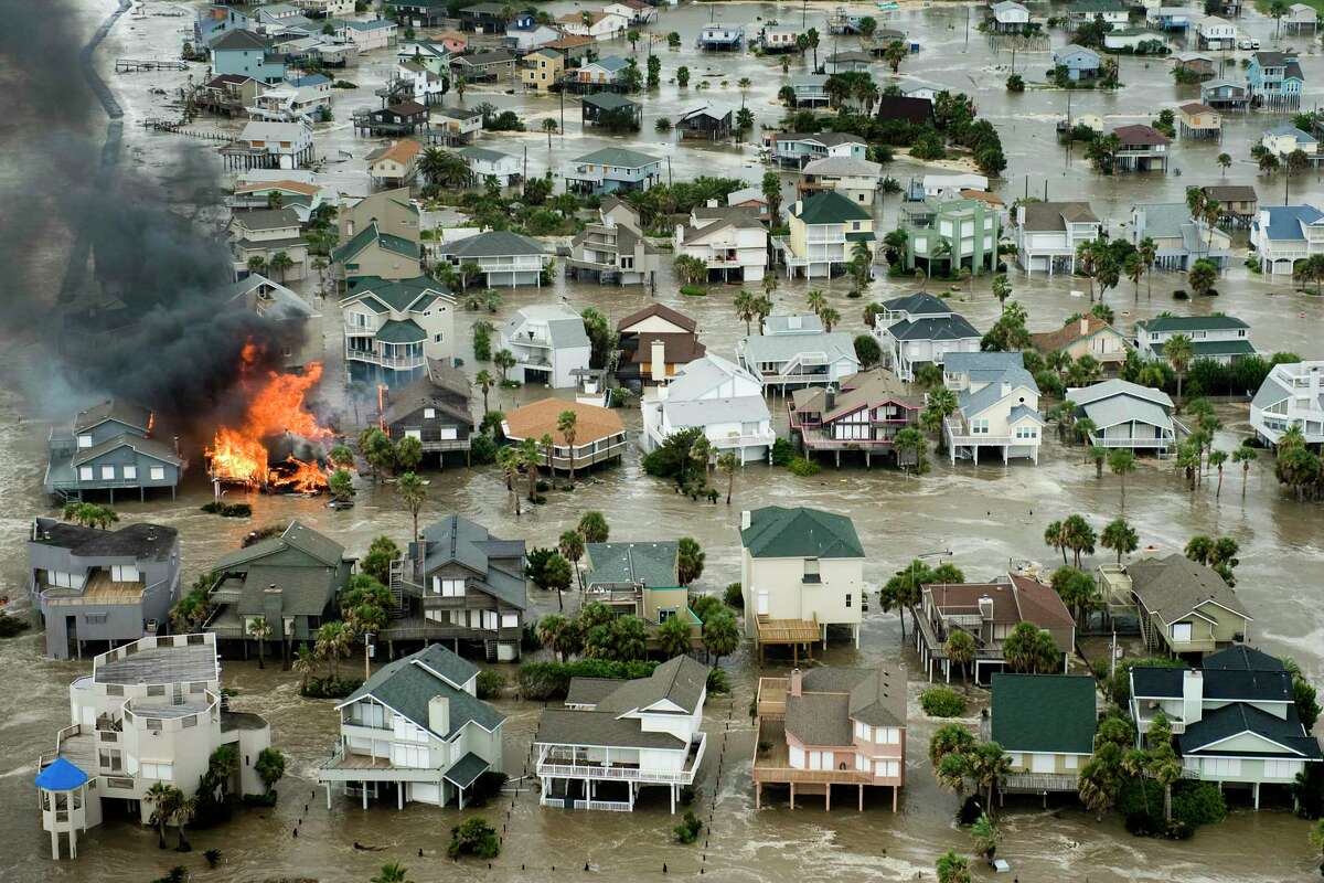 A house is totally engulfed in flames as floodwaters and crashing waves inundated beach homes on Galveston Island as Hurricane Ike approaches the Texas Gulf Coast, Friday, Sept. 12, 2008. ( Smiley N. Pool / Chronicle )