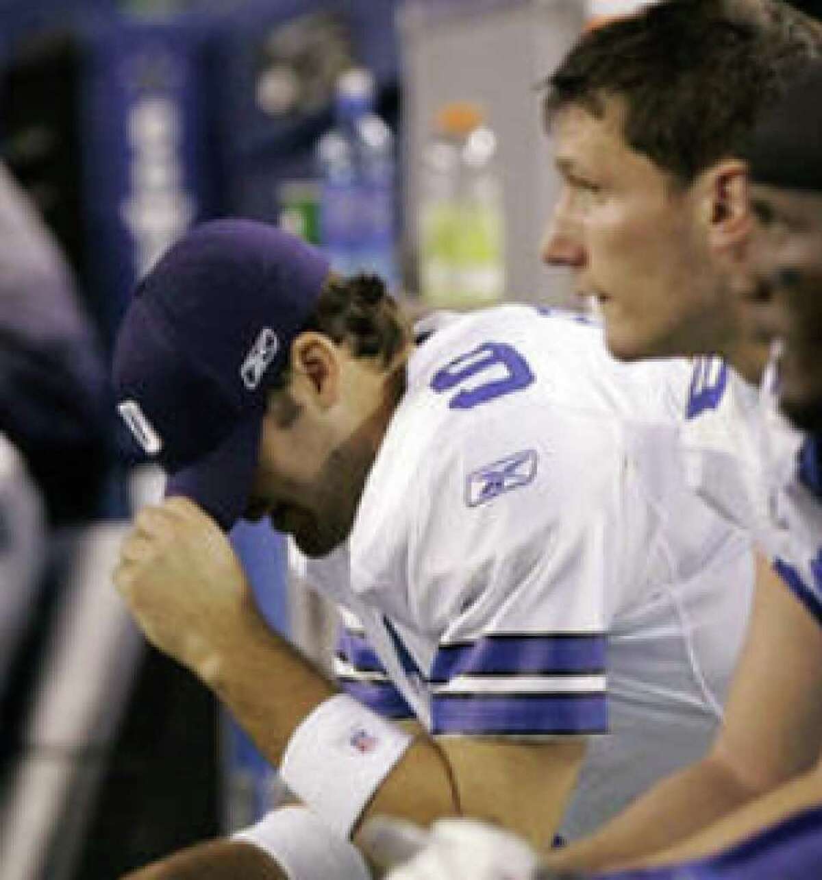 Cowboys quarterback Tony Romo (9) pulls his cap over his face late in Sunday's loss to the Chargers. The defeat, coupled with Philadelphia's win, dropped Dallas into second place in the NFC East.