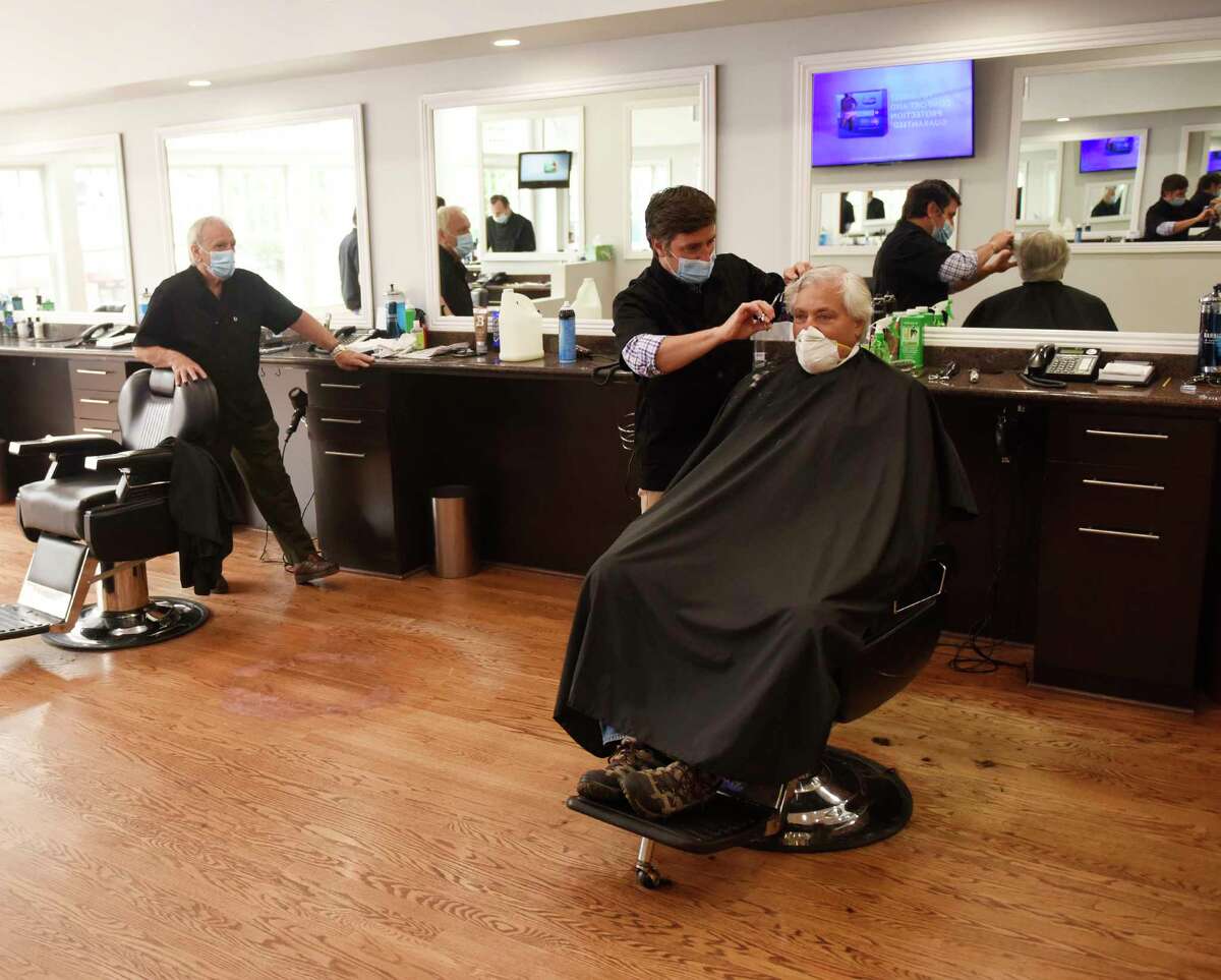 Riverside resident Jeff Ramer gets his hair cut by Antonio Merolla at Classic Barber of Greenwich in Greenwich, Conn. Monday, June 1, 2020. Barbershops, hair salons, and casinos in Connecticut were allowed to reopen with restrictions on Monday.
