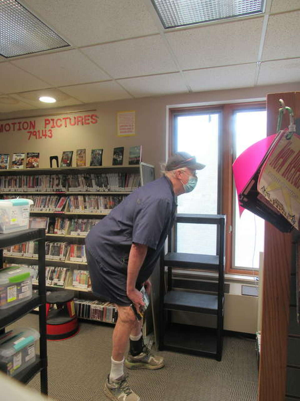 Rick Fuchs looks through the library’s popular DVD section on Monday.