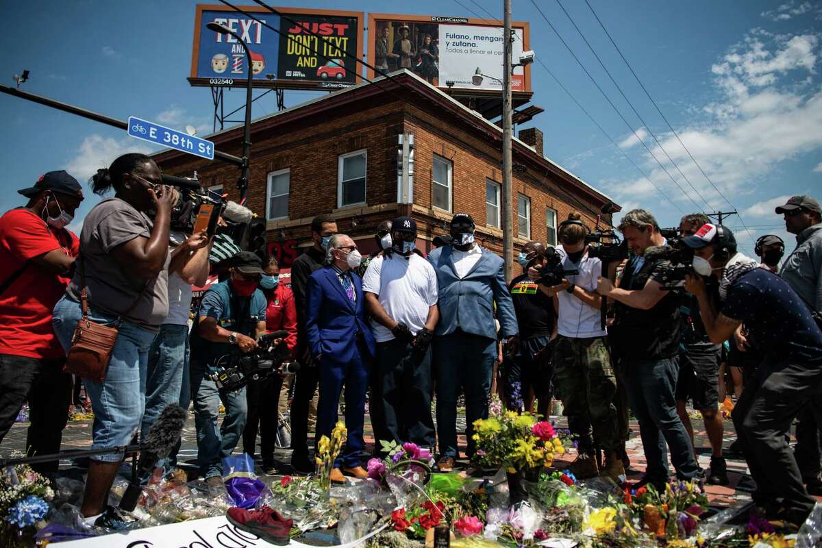 Terrence Floyd, the brother of George Floyd, center in white T-shirt, visits a memorial for his brother at the intersection of 38th Street and Chicago Avenue in Minneapolis on Monday.