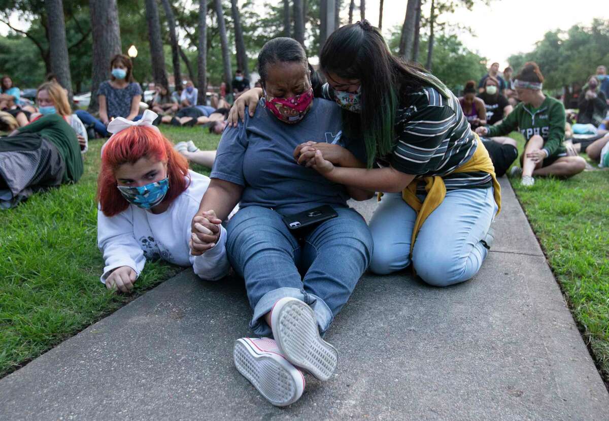 Janet Collins, a criminal justice teacher at Kingwood High School, is consoled by two students as she cries during the silent moment for George Floyd, who died in Minneapolis Police Department custody a week ago, Monday, June 1, 2020, at Town Center Park in Kingwood. The event, which was organized by two Humble ISD teachers, invited participants to lay down silently for eight minutes and forty-six seconds to honor Floyd's life.