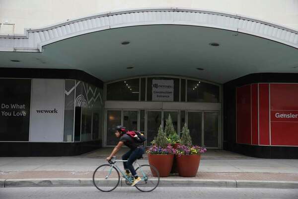 A cyclist rides by the former San Antonio Children's Museum building at 305 East Houston Street, Thursday, Jan. 30, 2020. The building is undergoing construction and will be the future site of WeWork. The company offers works space for startups.