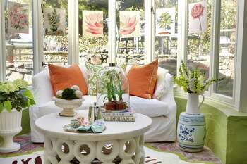 Carey Karlan, owner of Last Detail Interior Design in Darien, considers her home's conservatory - with its larger outdoor planters, garden stools, terrarium, indestructible indoor/outdoor coffee table, green garden-like etagere, botanicals, and pitchers of flowers - a summer retreat. "I have coffee here every morning," she says.