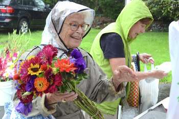 Longtime New Canaan resident Jeannie Hart makes a flower purchase at the weekly New Canaan Farmers Market in 2018.