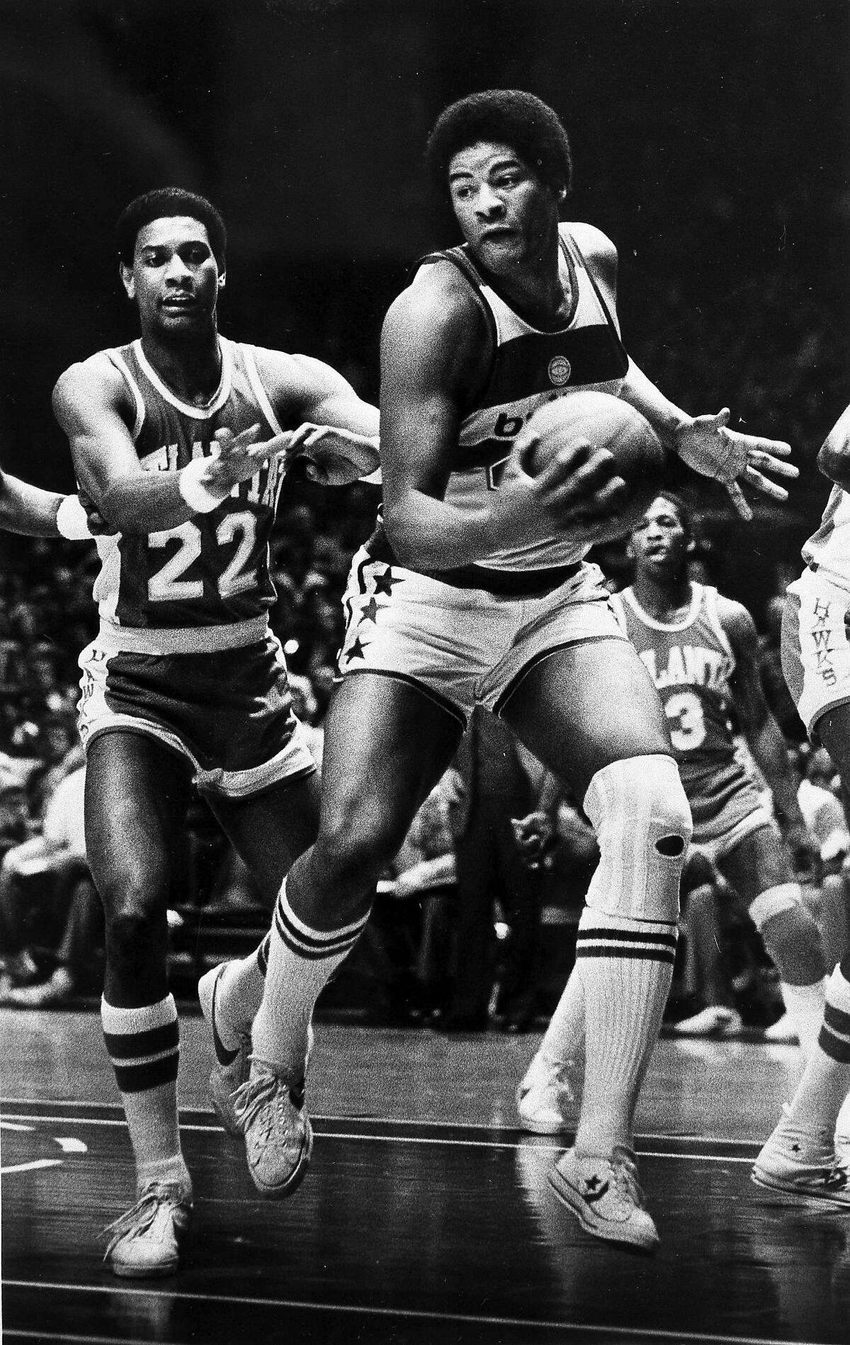 FILE - In this Jan . 30, 1979, file photo, Wes Unseld of the Washington Bullets takes in an offensive rebound against John Drew (22) of the Atlanta Hawks during the first half of an NBA basketball game in Landover, Md. Unseld, the workmanlike Hall of Fame center who led Washington to its only NBA championship and was chosen one of the 50 greatest players in league history, died Tuesday, June 2, 2020, after a series of health issues, most recently pneumonia. He was 74. (AP Photo/FIle)