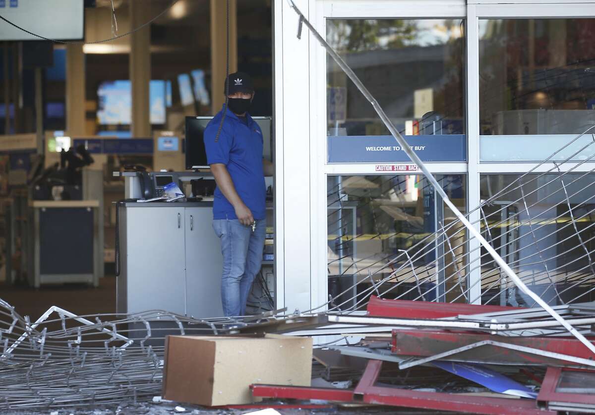 An employee surveys the damage at a Best Buy store in Fairfield, Calif. on Tuesday, June 2, 2020 the morning after looters broke into the store and stole electronic equipment one week after George Floyd was died in police custody in Minneapolis.