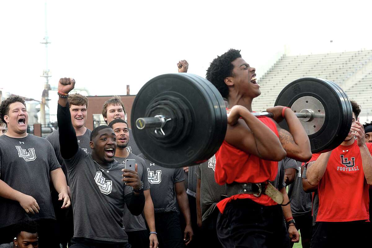 Lamar's teammates get in the spirit as Marcellus Johnson makes his next lift during the football team's annual Night of Champions weightlifting event on the football field Tuesday night. Photo taken Tuesday, April 30, 2019 Kim Brent/The Enterprise