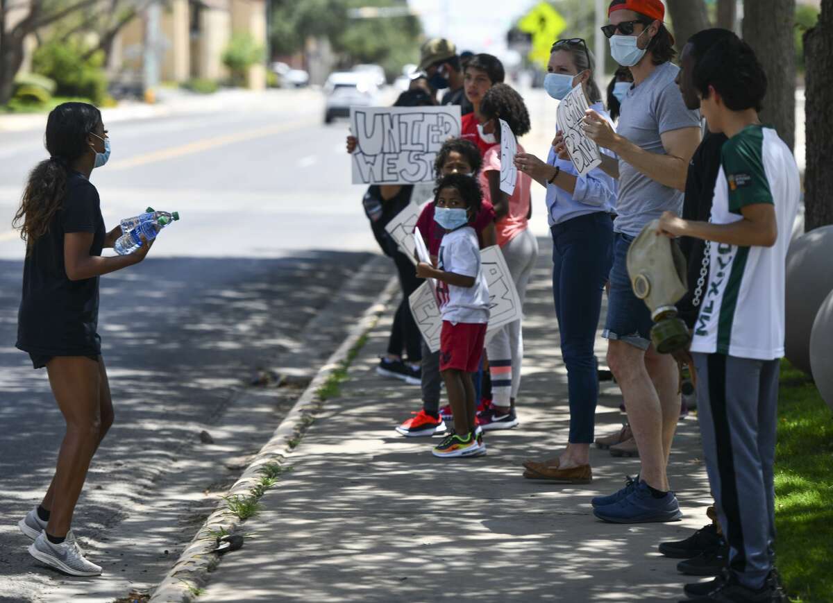 Latriceia Smith makes sure protestors have water before marching Tuesday, June 2, 2020 outside the Midland County Courthouse.