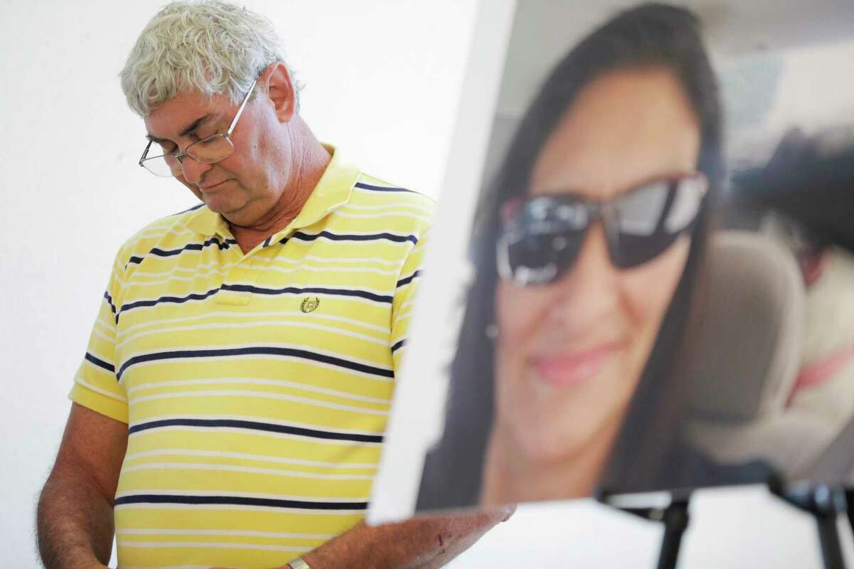John Nicholas, brother of Rhogena Nicholas, lowers his head next to a photo of his sister during a press conference on Thursday, July 25, 2019 in Houston.