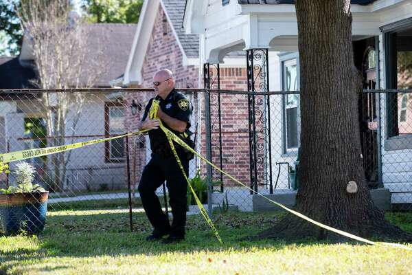 An officer takes down crime scene tape on Harding Street where two Houstonians were shot to death during a botched drug raid in January 2019.