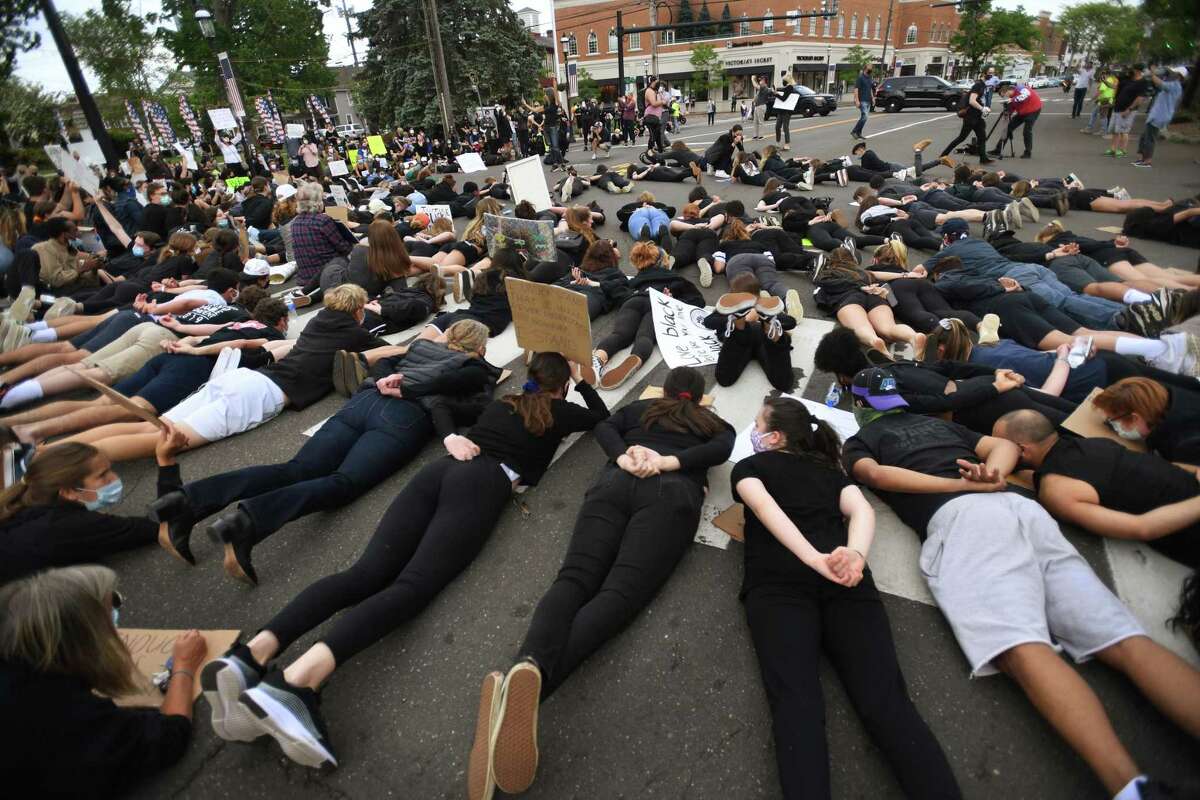 Protestors lie face down with hands behind their backs in the middle of the Post Road during an organized Black Lives Matter police brutality protest in Fairfield, Conn. on Tuesday, June 2, 2020.