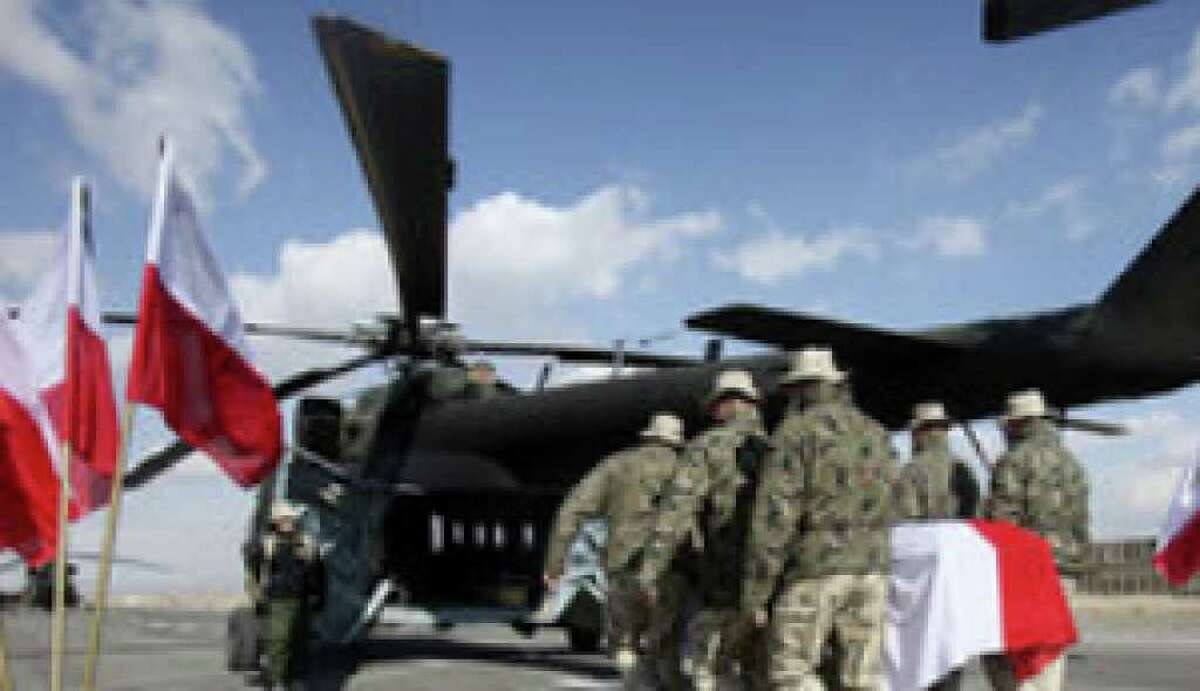 Polish soldiers carry the flag-draped casket of Pvt. 1 Michal Kolek, 22, into a Mil Mi-17 helicopter during a ceremony at Forward Operating Base Ghazni in Afghanistan. Around 150 Texas Army National Guard troops also took part in the ceremony.