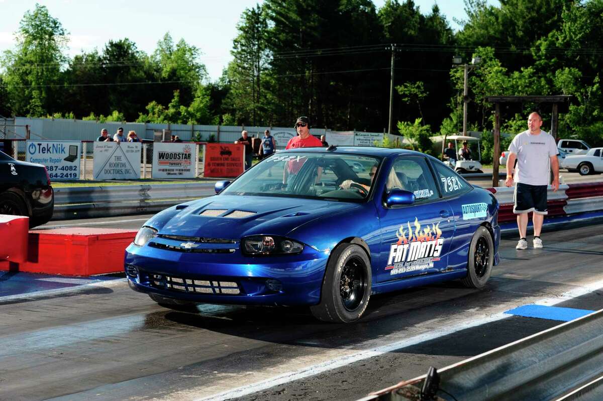Melissa Taylor of Hemlock scored a Street Trophy win in this Chevy Cavalier, sponsored by Fatt Matt's Barbecue in Munger.  The "Lil' Blue" entry, competes in all 4 divisions at NMD. Ben Wenzel Jr, looking on behind her, has the entry in among a 5-way tie for 11th place in Bracket II standings. (Submitted photo/Chris Simmons Photography)