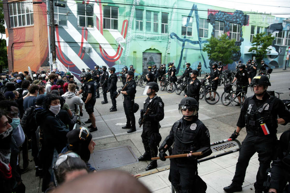 Seattle Police stand guard outside a precinct as people protest the death of George Floyd, in the Capitol Hill neighborhood of Seattle, Washington on June 1, 2020. - Major US cities -- convulsed by protests, clashes with police and looting since the death in Minneapolis police custody of George Floyd a week ago -- braced Monday for another night of unrest. More than 40 cities have imposed curfews after consecutive nights of tension that included looting and the trashing of parked cars. (Photo by Jason Redmond / AFP) (Photo by JASON REDMOND/AFP via Getty Images)