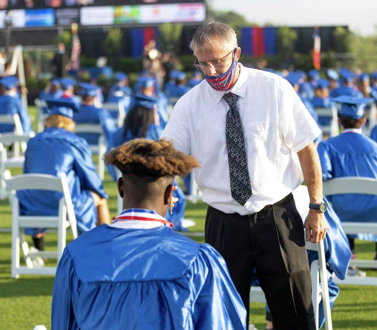 A staff personnel talks with a graduate before a Oak Ridge High School graduation ceremony at Woodforest Bank Stadium in Shenandoah, Wednesday, June 3, 2020. Ceremonies were split with a 8 a.m. and 8 p.m. time slots to allow 6 feet distancing between graduates.