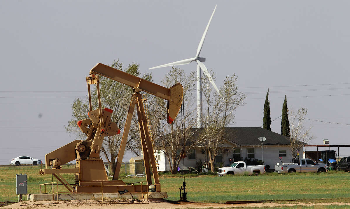 A house in Stanton, Texas has a pumpjack in front of it and a huge windmill behind it. Landowners and operators work hand in hand, but both sides must be proactive to be the best stewards of the land.