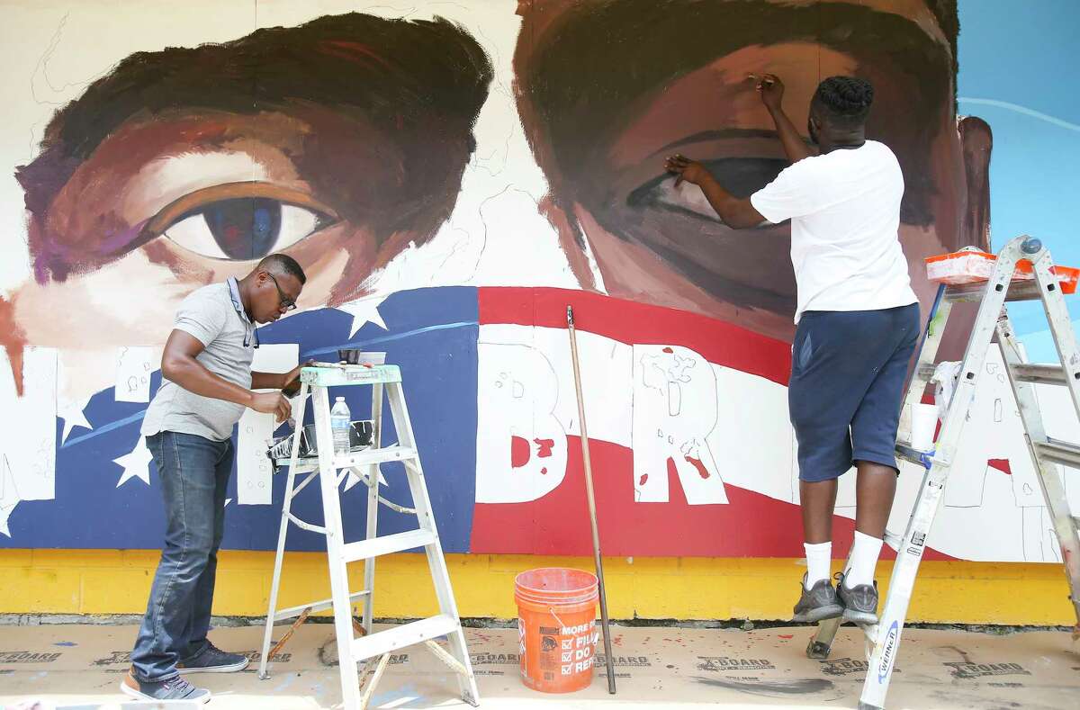 Artists Samson Adenugba, left, and Matthew Jeanbaptiste work on a mural inspired by George Floyed, on the side of the Breakfast Klub in Midtown on Tuesday, June 2, 2020.