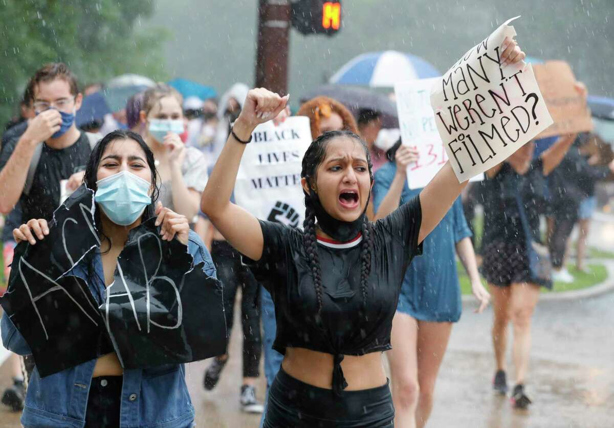Saachi Sharma, center, leads a group of people as protester march against the death of Houston native George Floyd along the Lake Woodlands Drive bridge near North Shore Park, Wednesday, June 3, 2020, in The Woodlands.