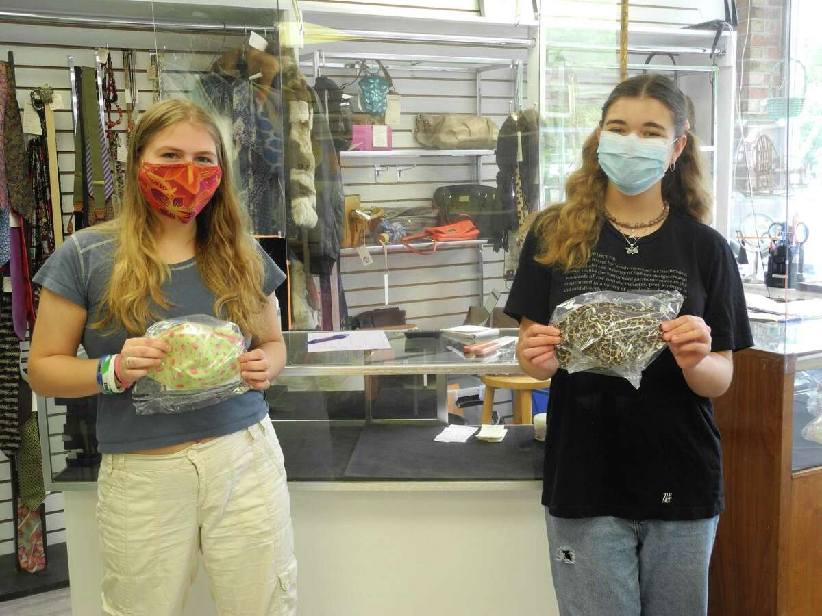 Nicole LaVorgna, left, and Eve Ogdon show off the face coverings for sale at the Turnover Shop in Wilton, CT, made by shop volunteer Janel Cassara. Both are 2018 Wilton High School graduates. LaVorgna is home for the summer from Endicott College, Ogdon from Tufts University.