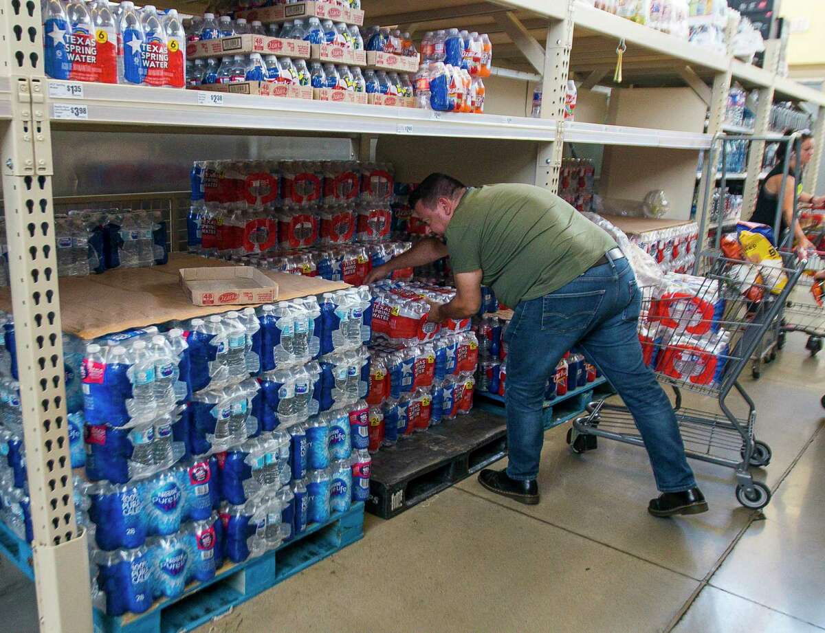 You can stock up on supplies all year-round to avoid getting stuck without when a storm hits. Fernando Lorenzo grabs four cases of water at the Montrose Market H-E-B on West Alabama Street during his lunch break, Wednesday, July 10, 2019.